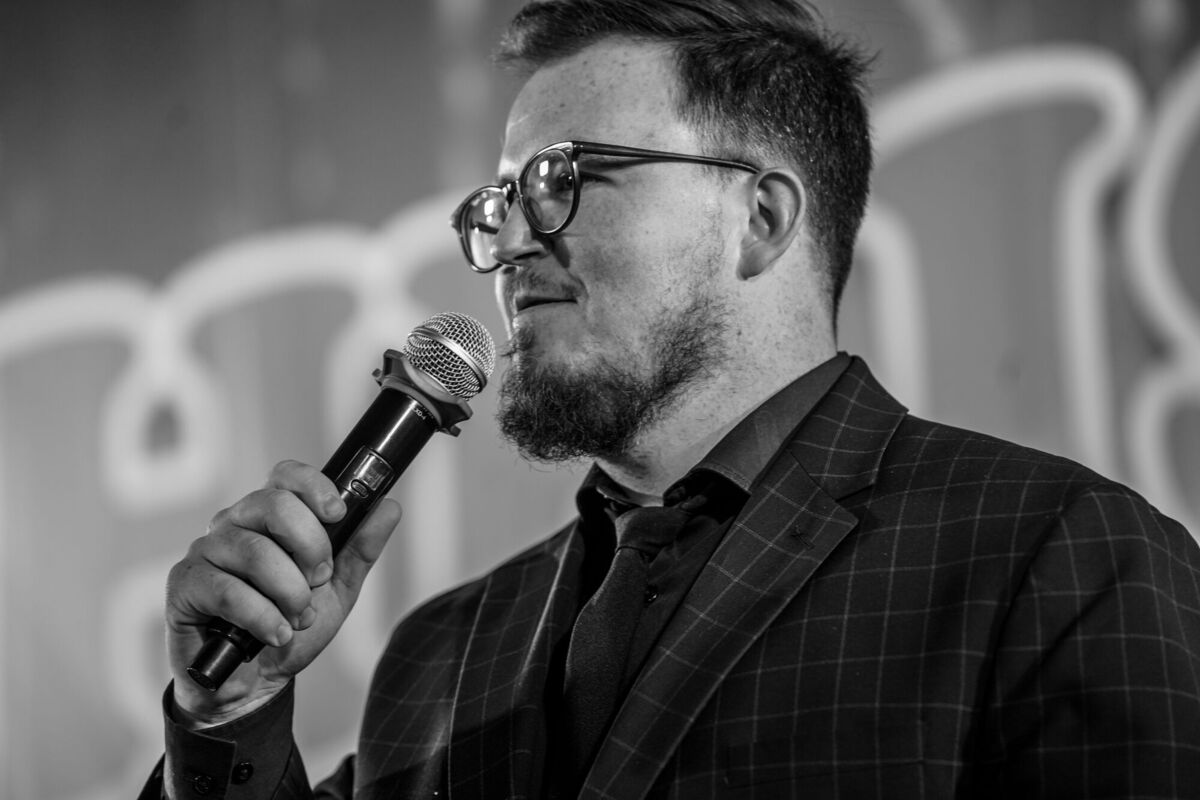 Preaching into a microphone, in black and white